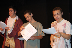 Three people on stage conducting a Reader's Theater session